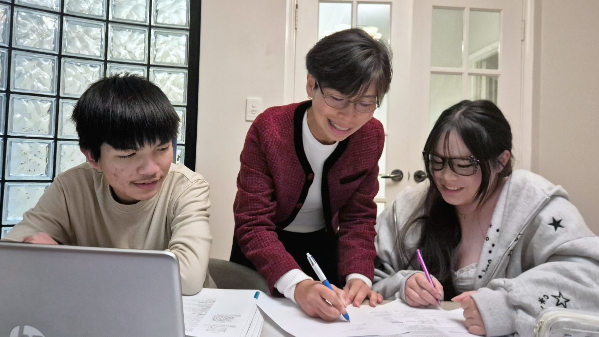 A Young Einsteins tutor helping two students with their worksheets